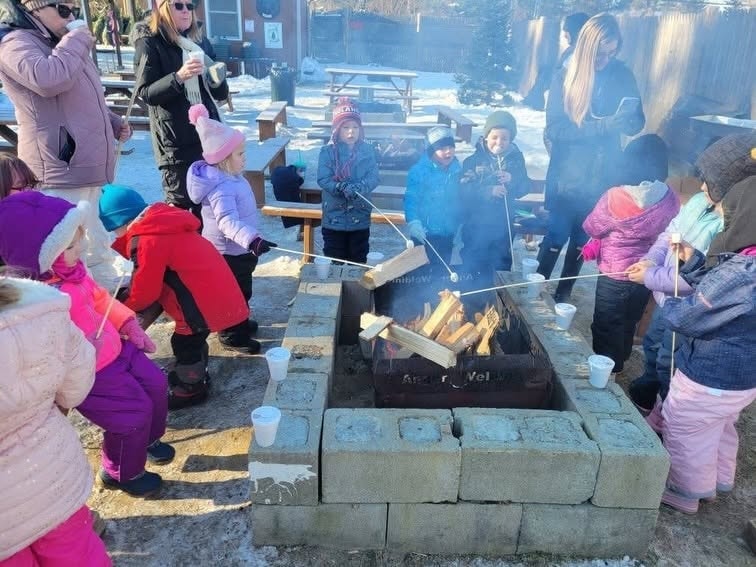 Children roasting marshmallows around a fire pit at Noel's Tree Farm